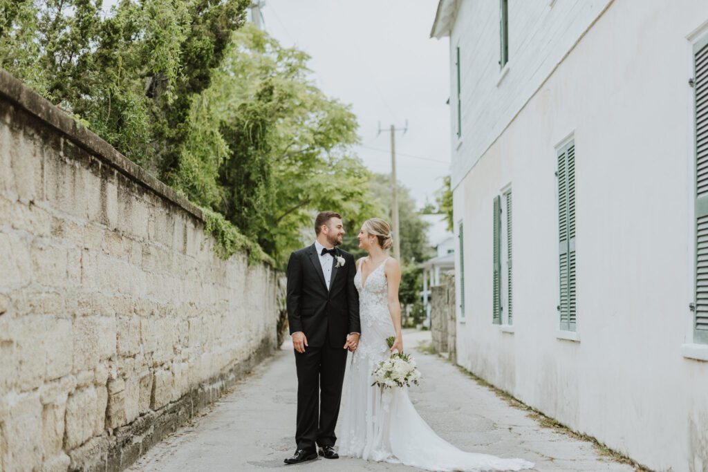 groom and bride standing the middle of historic street of st. augustine