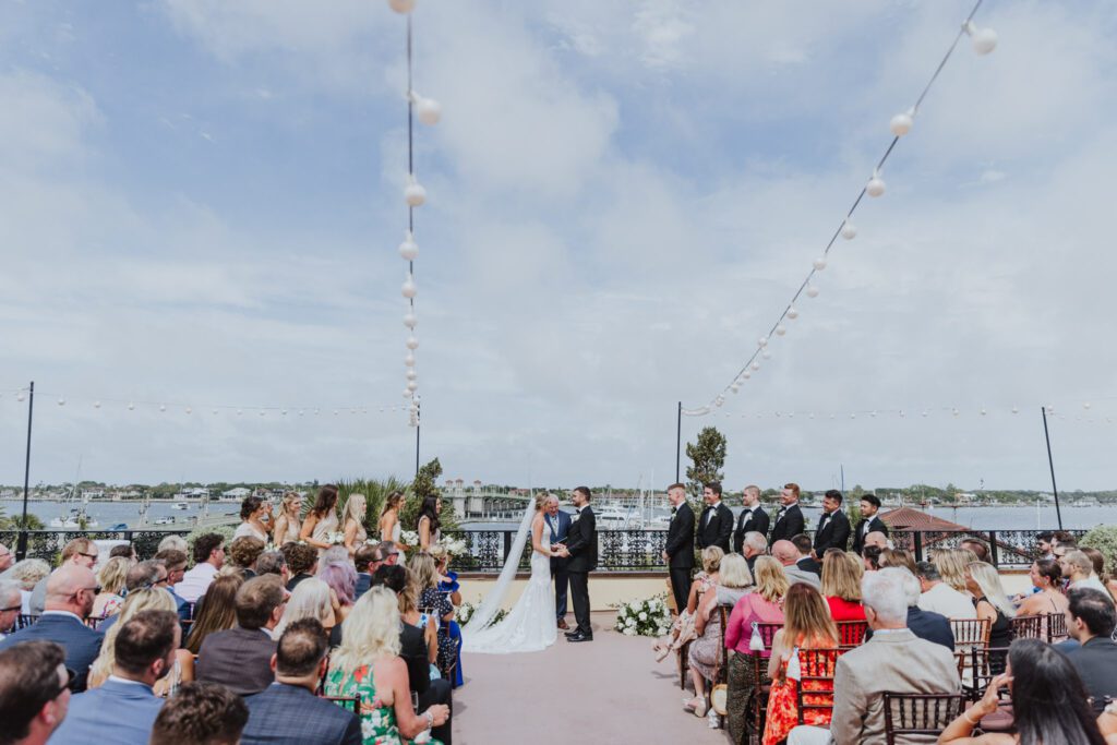 fully view of ceremony on the rooftop of the white room with st. augustine bride in the background