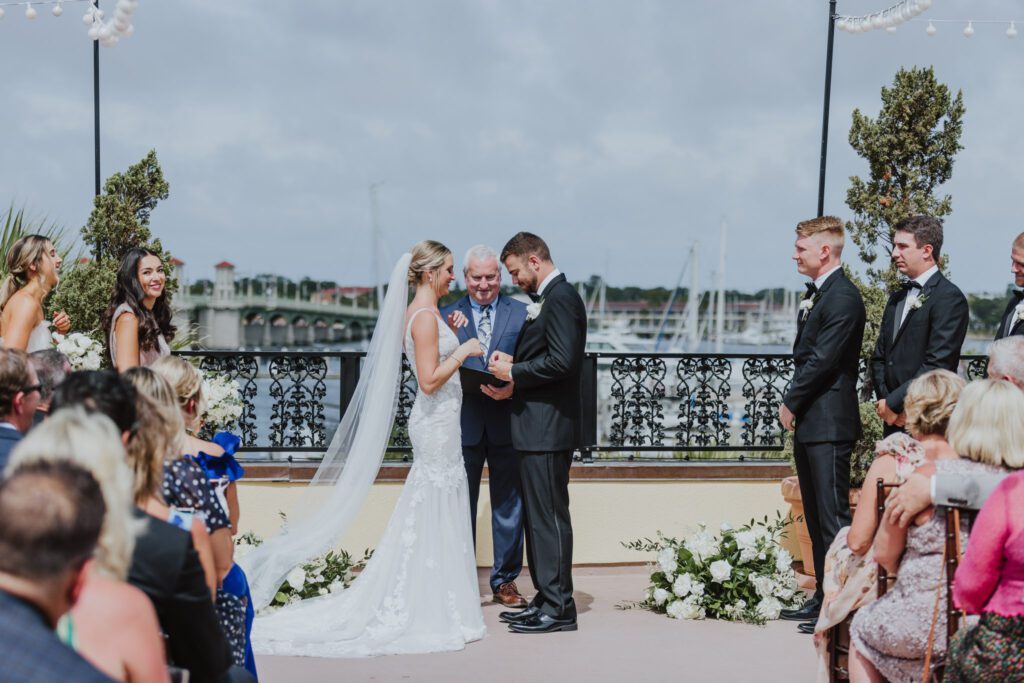 bride and groom exchanging rings during rooftop ceremony at the white room in st. augustine