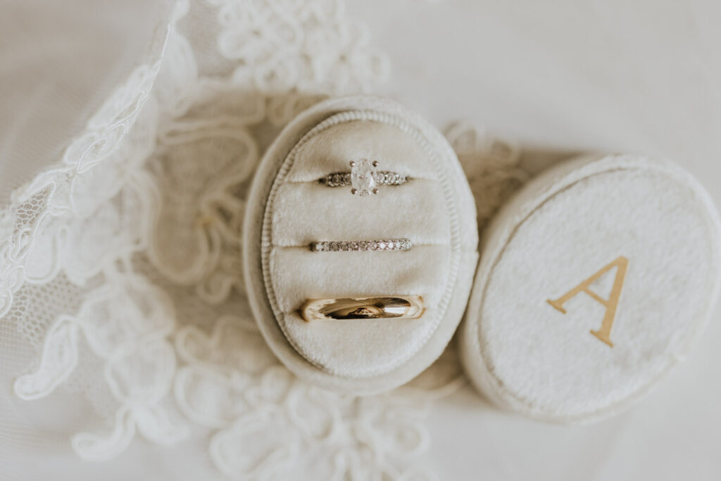 wedding bands and engagement ring in velvet ring box on piece of bride's veil