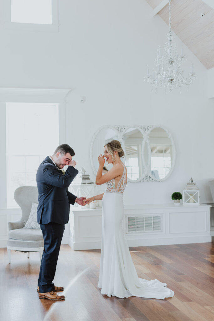 groom and bride wiping away their tears of joy after seeing each other for the first time on their wedding day while standing inside villa blanca