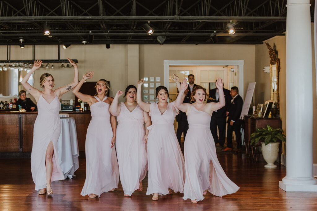 bridesmaids walking in together as a group into the white room reception